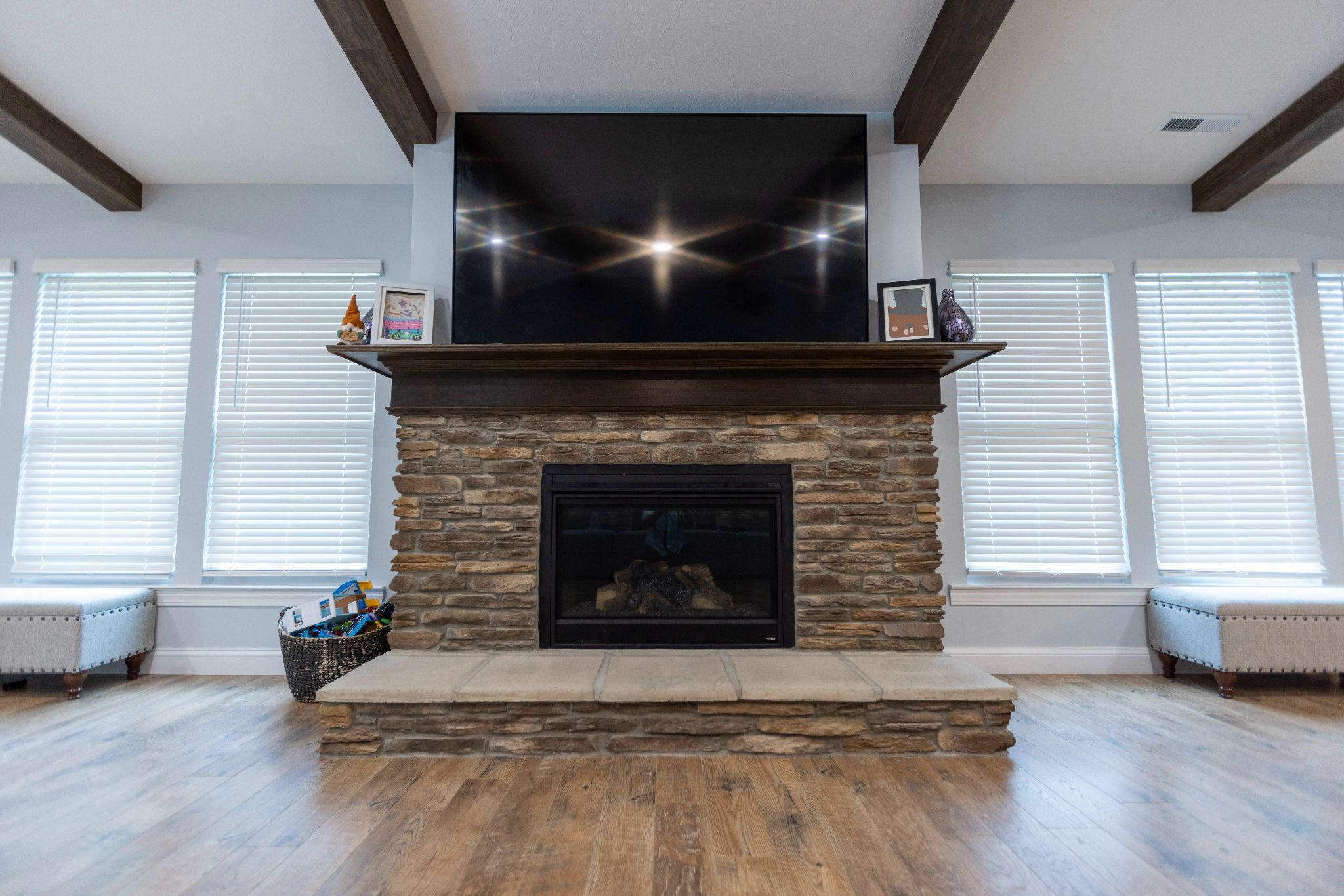 Stacked stone wrapped fireplace & custom hearth